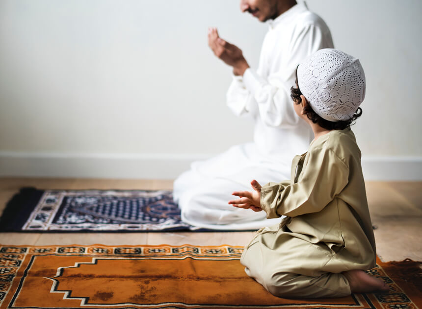 Bambino che prega al fianco del padre durante il Ramadan
