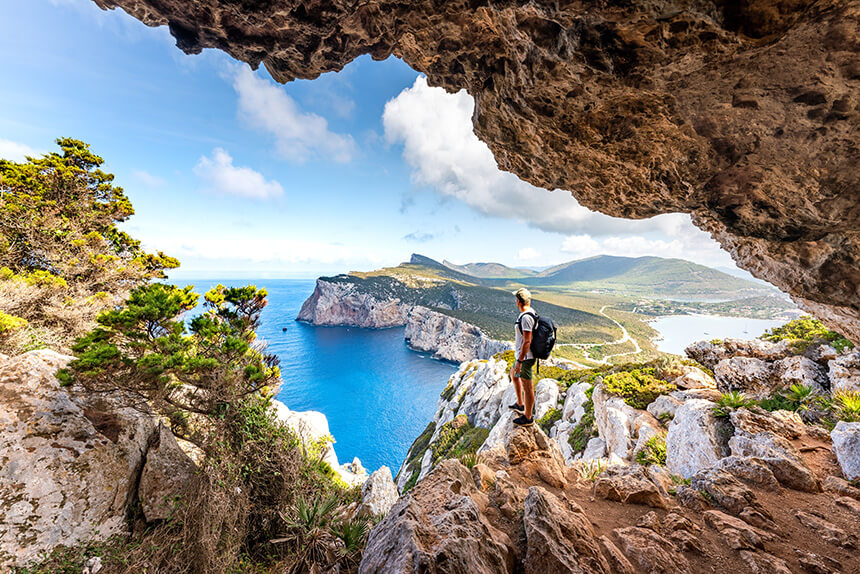 Capo Caccia, escursionista che ammira il panorama da una grotta. Sardegna