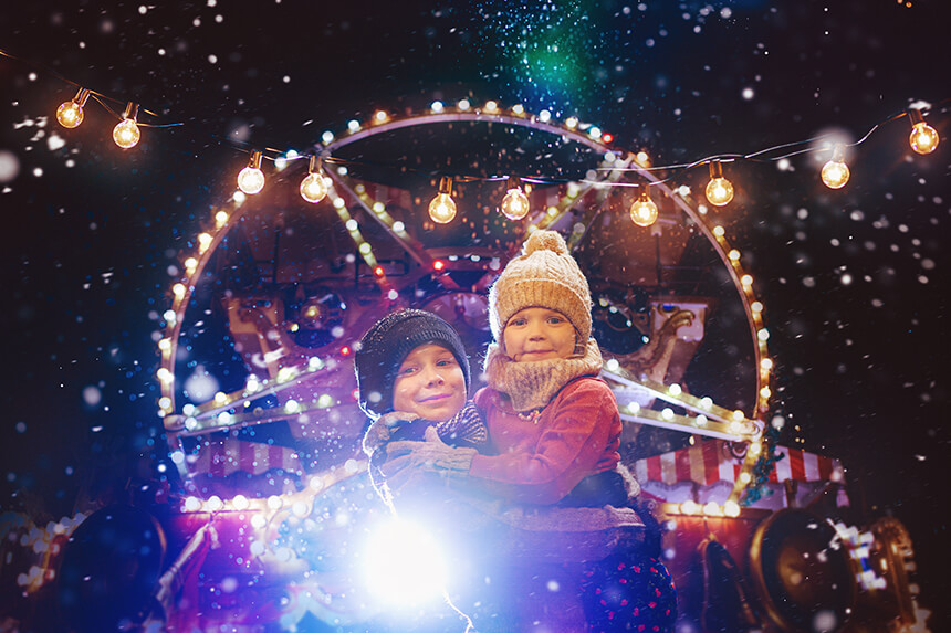 Bambini frequentano il luna park la sera sulla neve